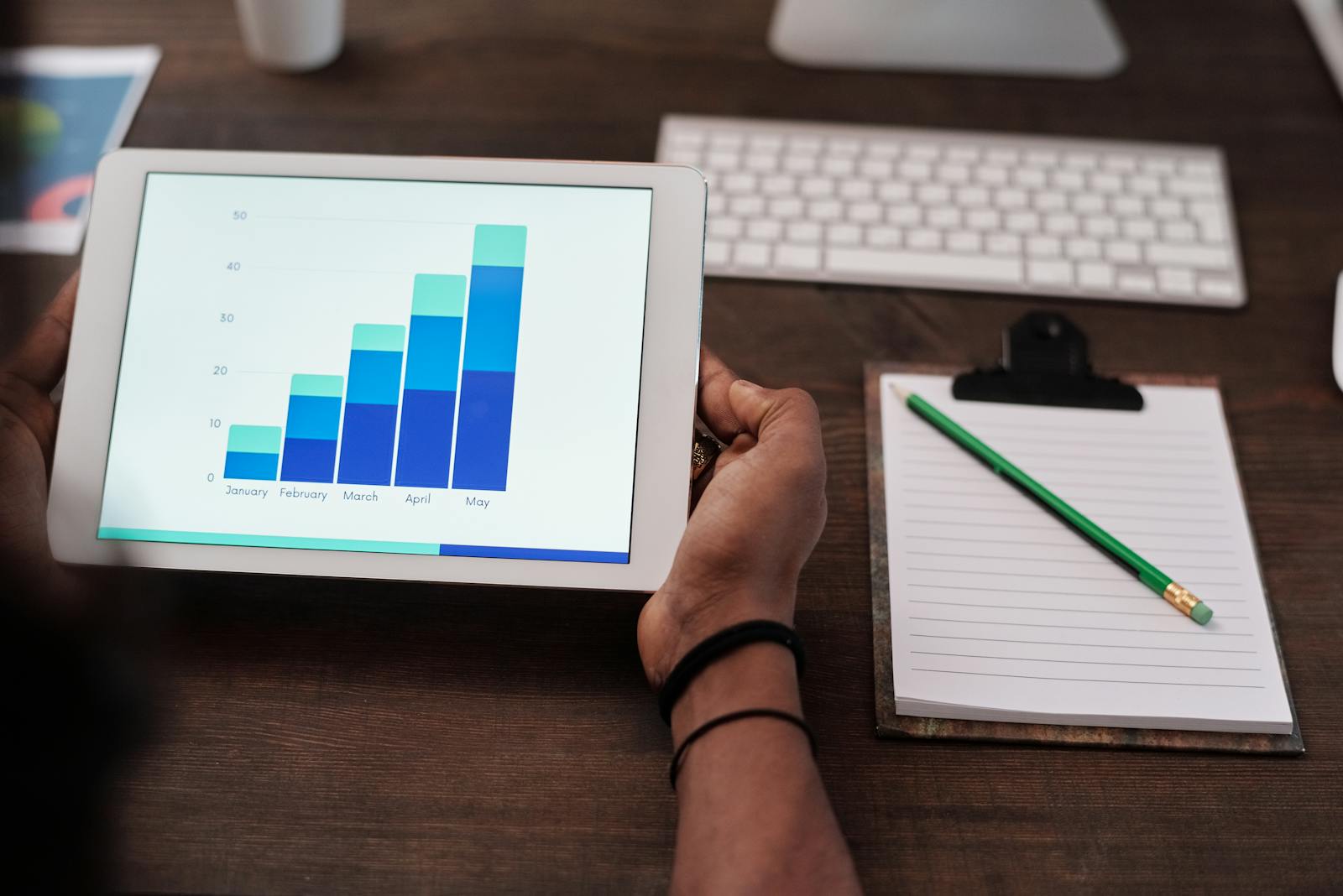 Tablet showing growth analytics beside a marketing workspace